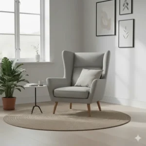 A modern grey wingback armchair with minimalist lines and light oak tapered legs in a bright, clean interior.