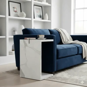 High-end white marble C-shaped side table positioned next to a plush navy velvet sofa in a modern lounge.