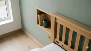 A grey fabric upholstered ottoman double bed frame with the base lifted to reveal spacious under-bed storage for a small bedroom.