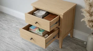 A narrow wooden bedside cabinet featuring two smooth-gliding drawers for organised bedroom storage.