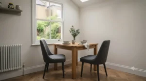 A small square dining table neatly tucked into a kitchen corner to maximise space in a terraced house layout.