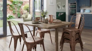 Slimline black metal frame chairs paired with a reclaimed wood dining table in a bright, neutral-toned dining space.