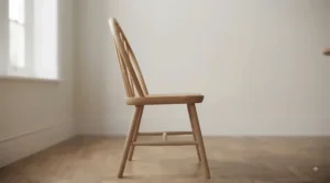 Clean side profile view showing the graceful silhouette and angled legs of a classic bow-back Windsor dining chair.