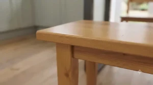 Close-up view of the smooth, easy-to-clean scratch-resistant wood grain finish on an affordable dining bench.