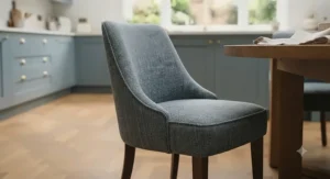 Close-up of plush grey velvet upholstered dining chairs showing button-tufted detailing and dark wooden legs.
