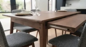 Solid walnut dining table paired with upholstered chairs in a stylish London apartment dining space.