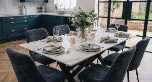 A marble effect dining table styled with elegant tableware, candles, and a floral centrepiece ready for dinner guests.