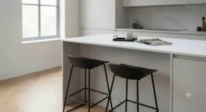 Minimalist matte black backless breakfast stools inside a clean, neutral-toned kitchen