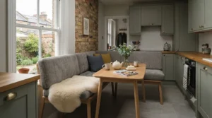 Grey upholstered small dining bench creating a cosy breakfast nook in a compact UK kitchen.